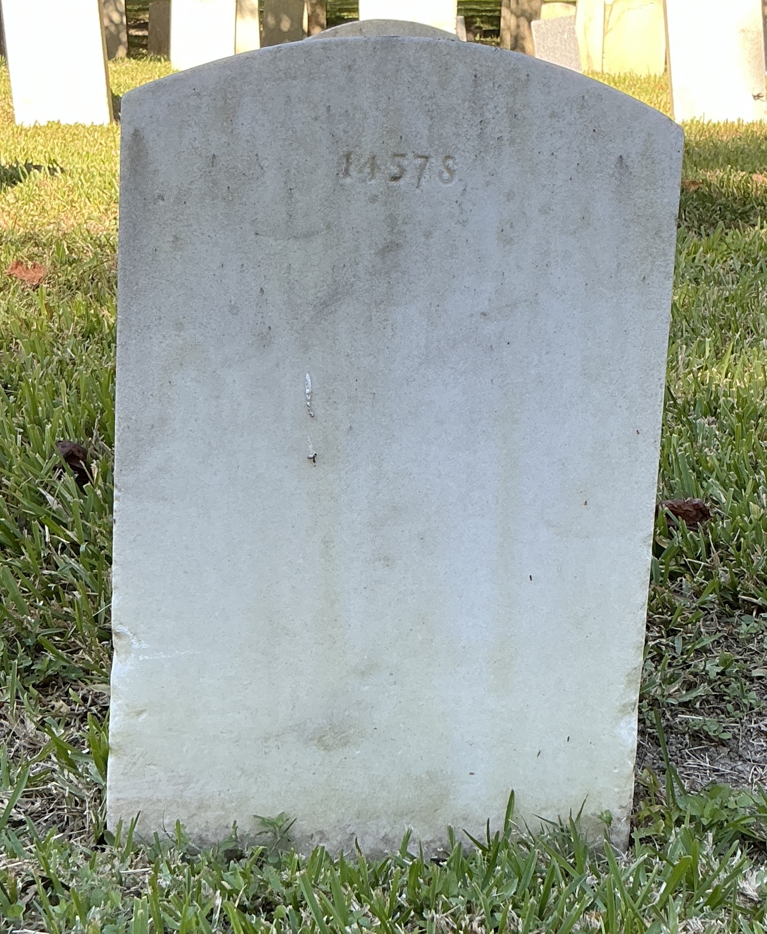 Back of upright marble headstone with flat face.