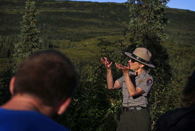 a ranger speaking to people at an outdoor amphitheater