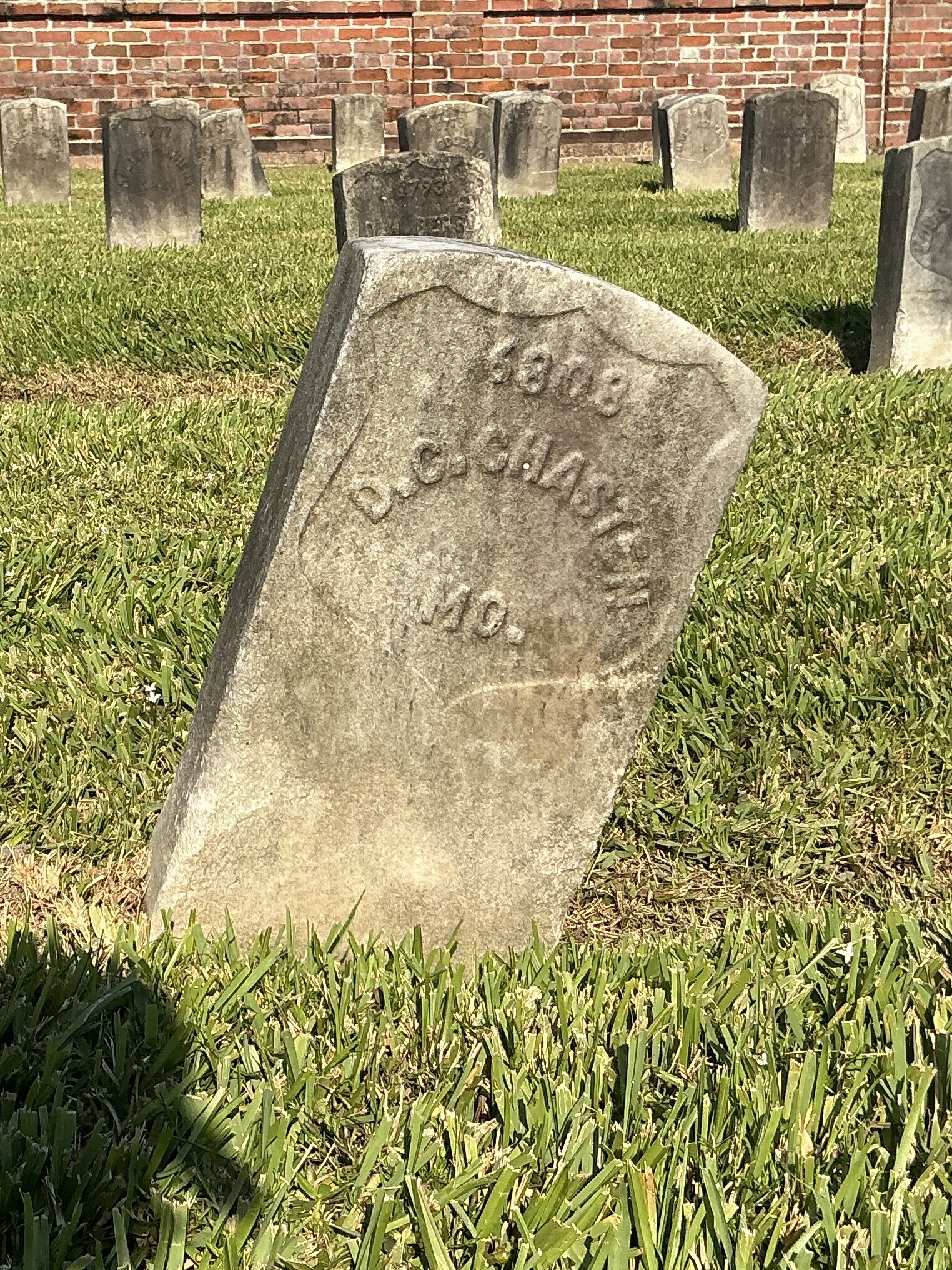 Front of historic upright marble headstone with recessed shield face.