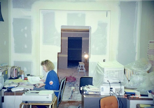 Woman working at desk during the construction of headquarters addition.