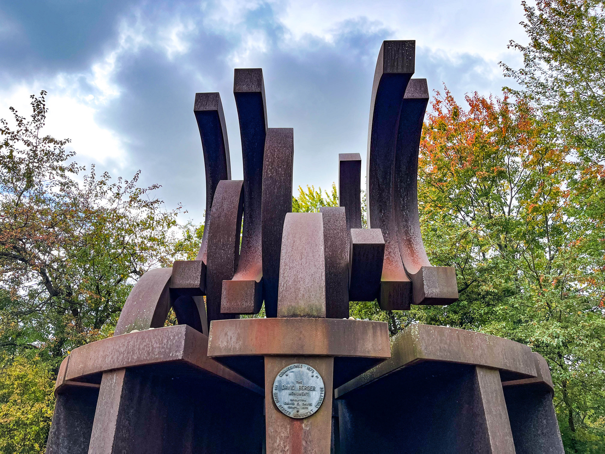 Metal memorial made of elevated semi-circles, or broken Olympic rings