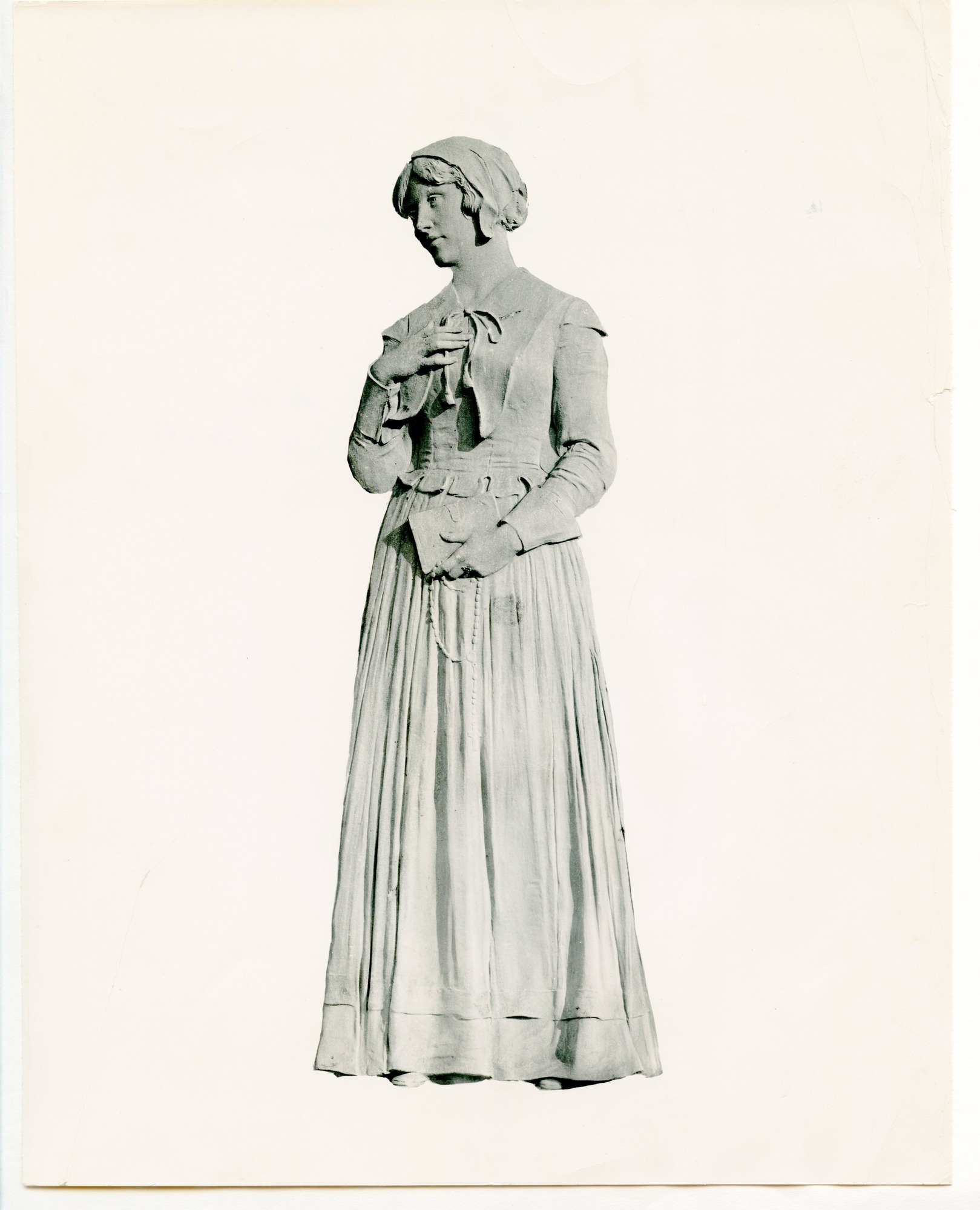 Bas-relief of a young woman in period clothing silhouetted against blank background.