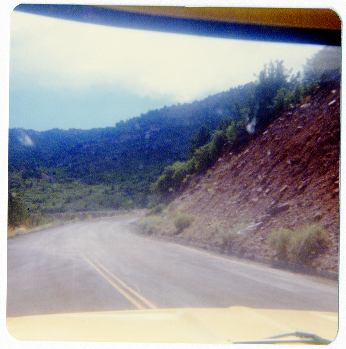View through car windshield of the Kolob Terrace Road - North Unit and surrounding landscape.