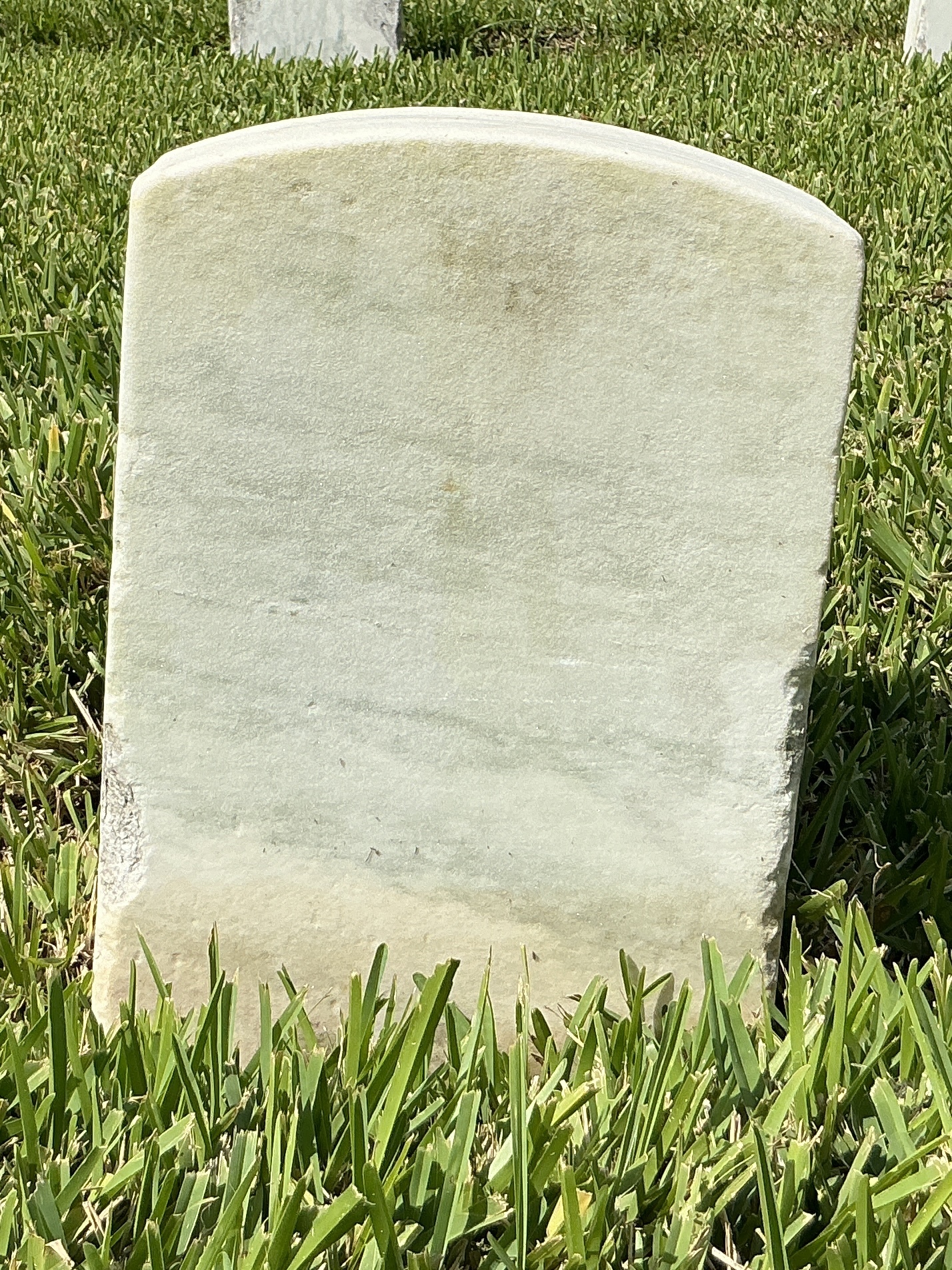 Back of historic upright marble headstone with recessed shield with recessed lettering face.
