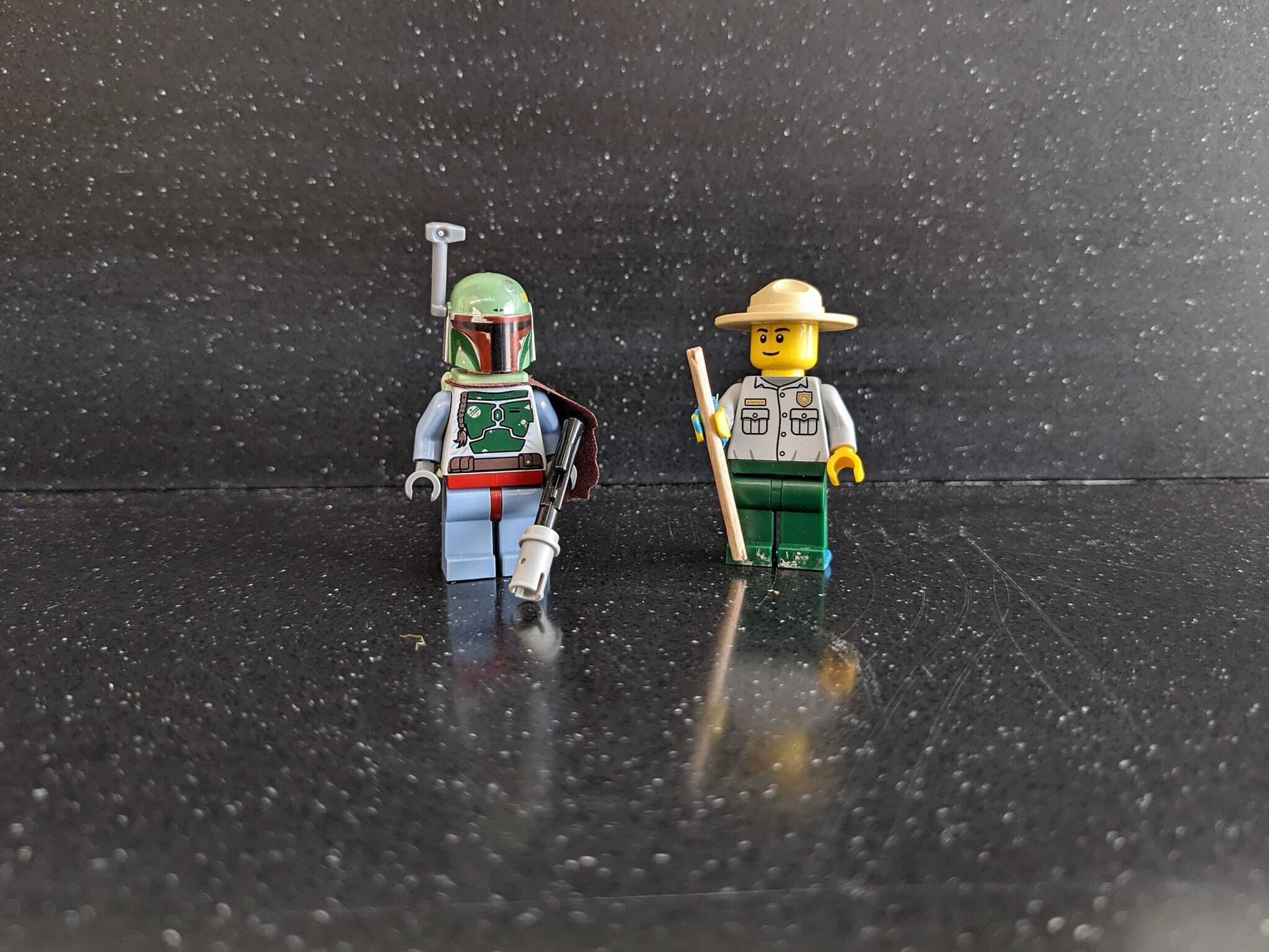 Lego park ranger and Lego star wars Bobba Fet figure, wearing green helmet and gray armor. 