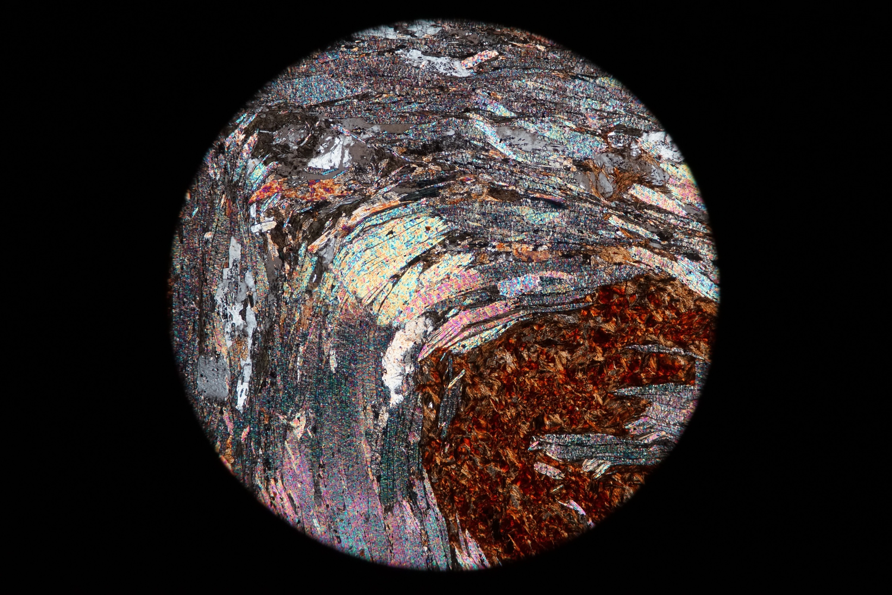 Circular microscopic image of rock structure.