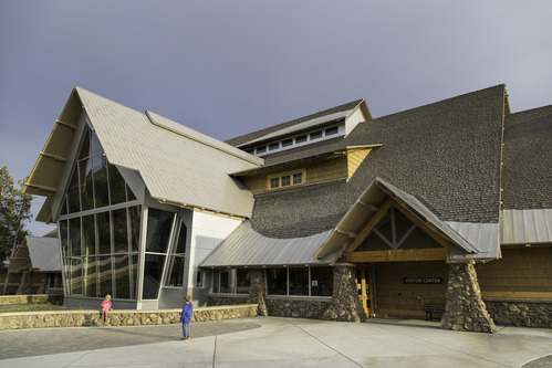 Tall building with windows facing the geyser with two children standing outside.