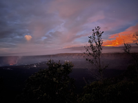 Two volcanoes erupt in the early morning. A red glow can be seen from both summits. 