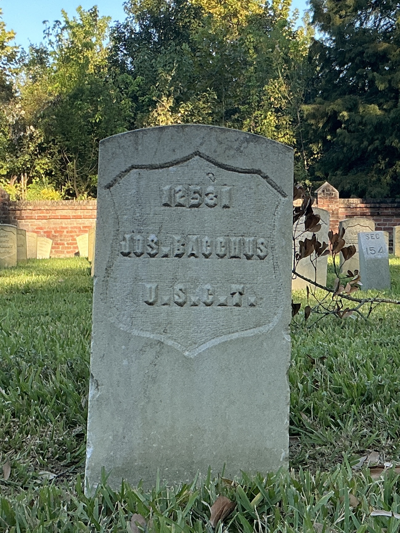Front of historic upright marble headstone with recessed shield face.