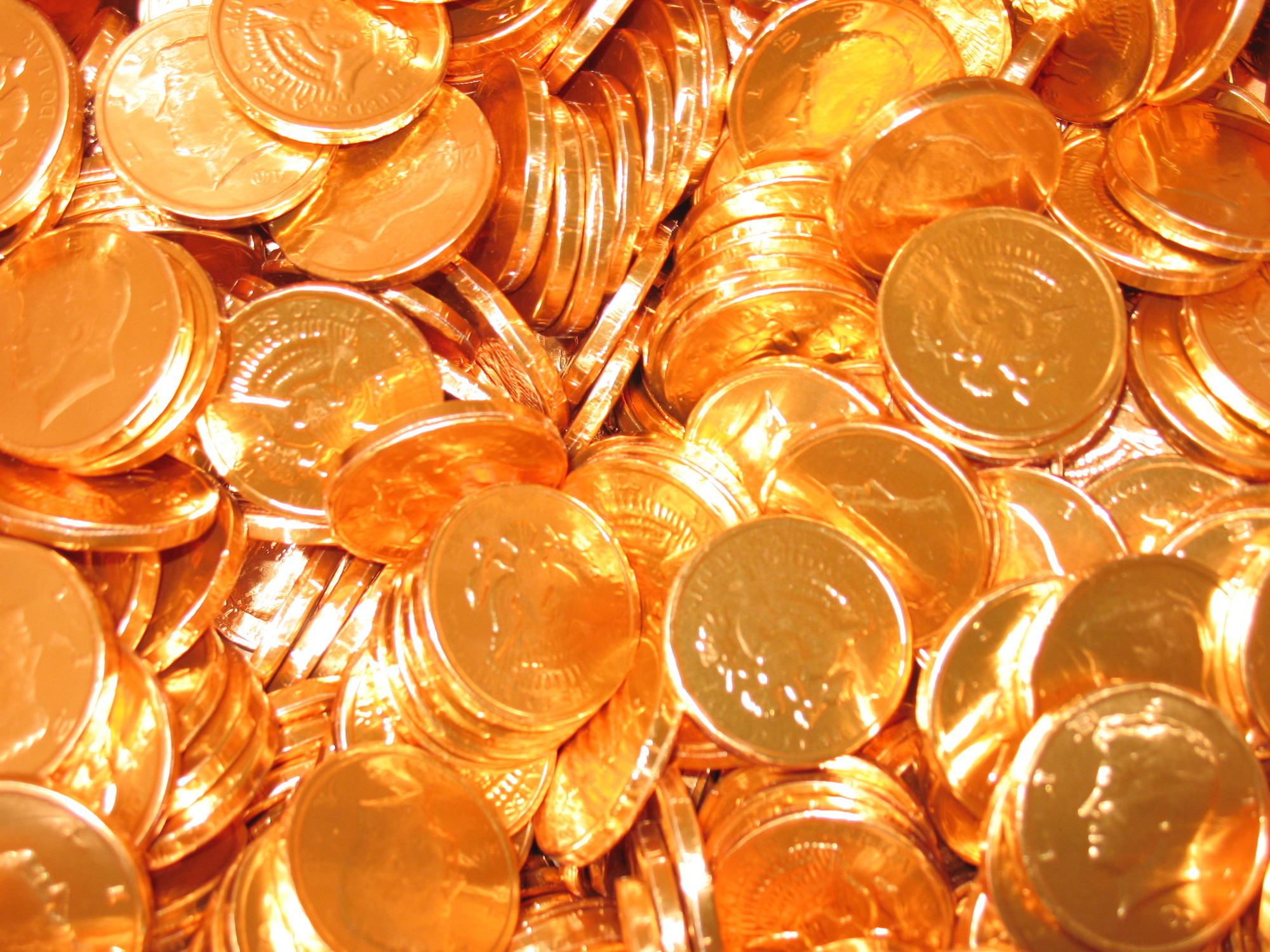 A large number of chocolate coins sit in a pile. 