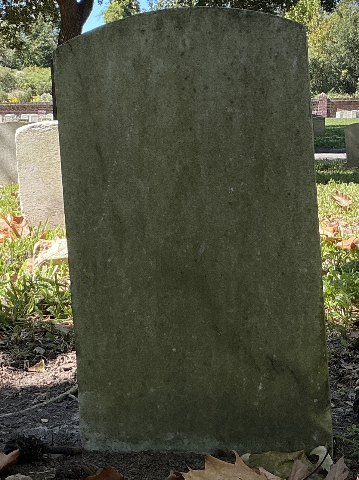 Back of upright marble headstone with flat face.