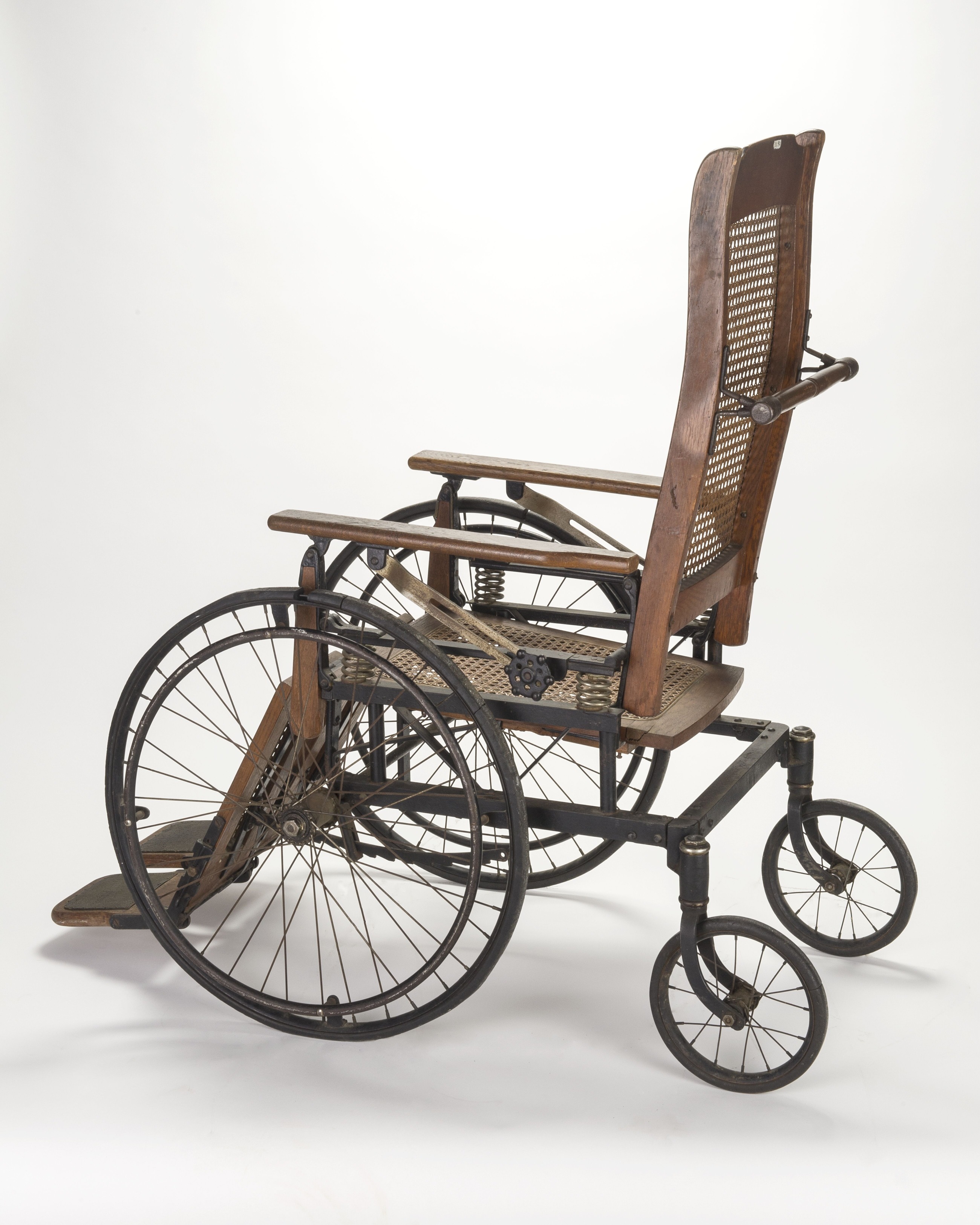 A large wood chair mounted to a steel frame wheelbase.