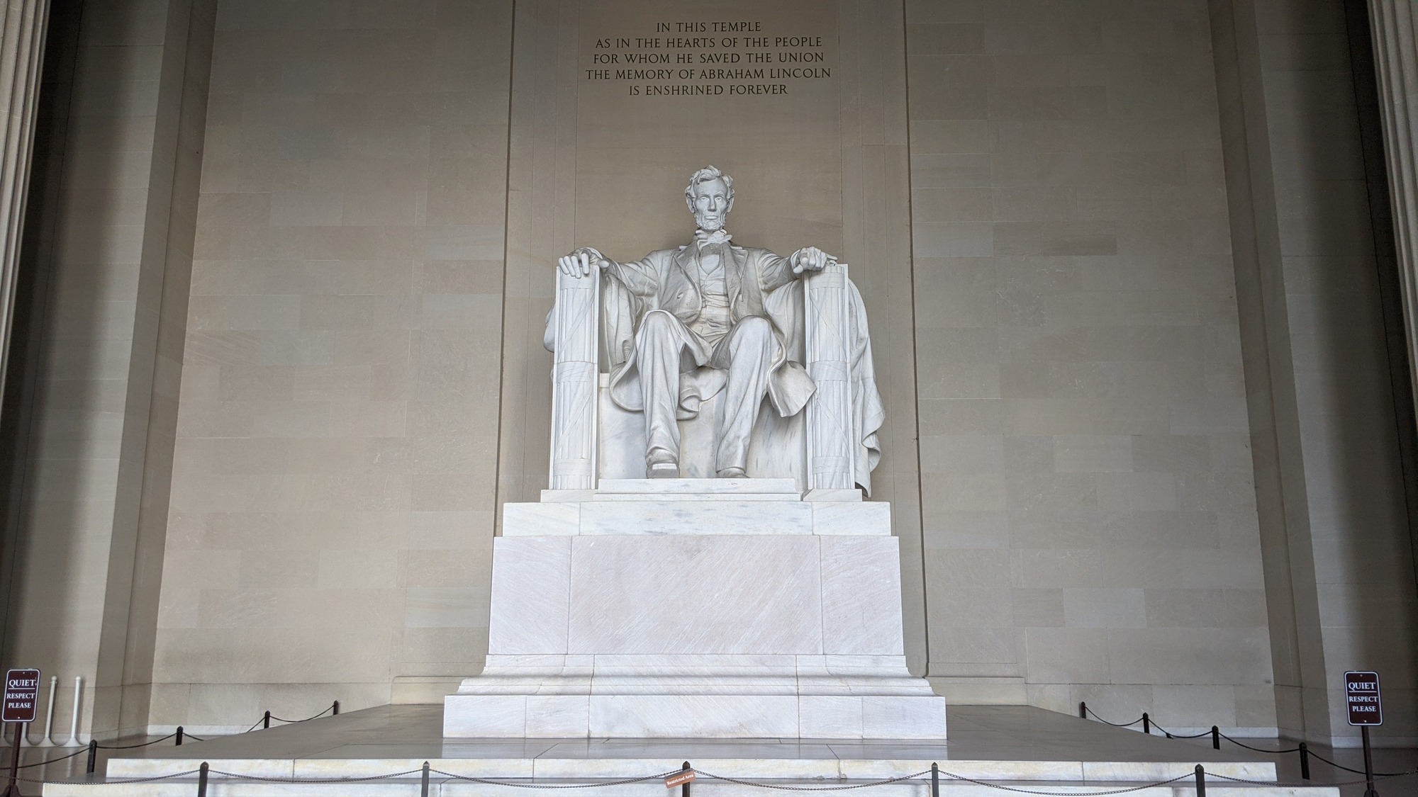 Large white statue of Abraham Lincoln seated inside the Lincoln Memorial chamber
