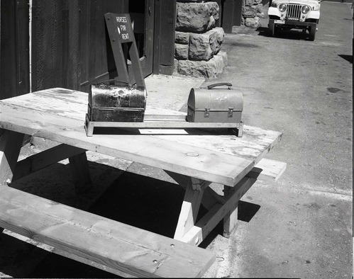 BW Photos of maintenance equipment. Lunch pails in rack on picnic table. Sign in background reads: Horses for Rent.