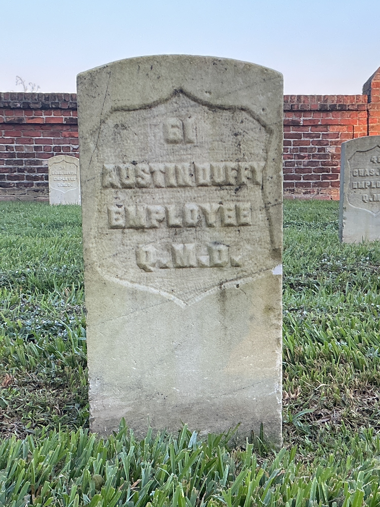 Front of historic upright marble headstone with recessed shield face.