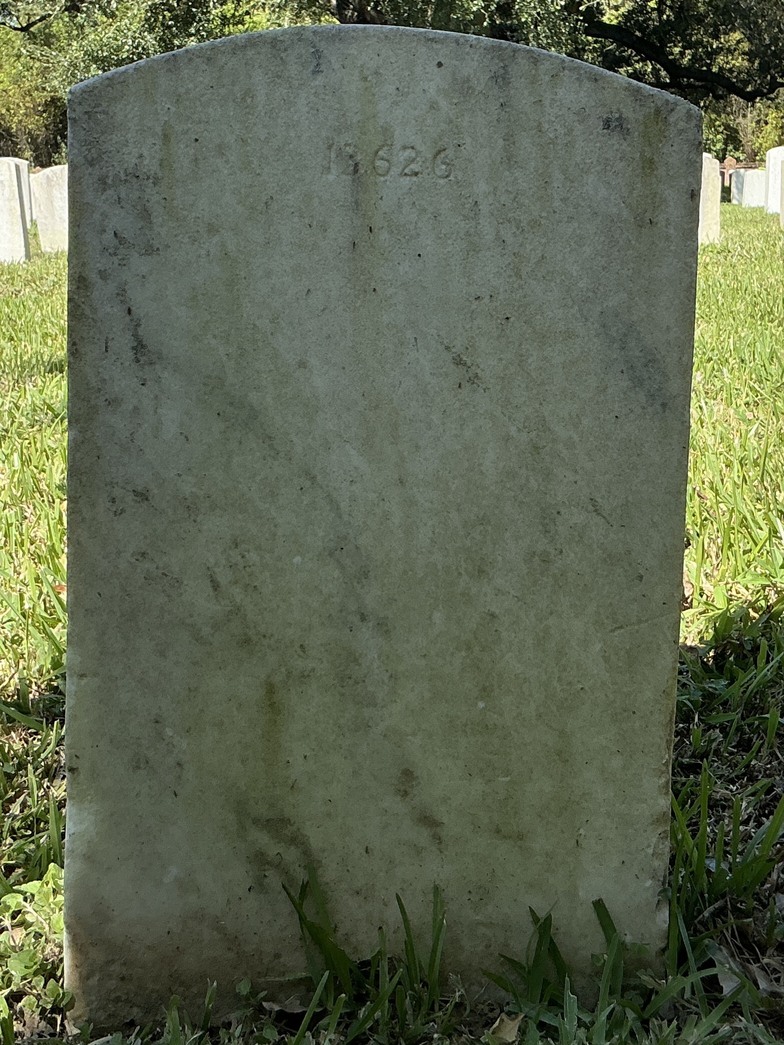Back of upright marble headstone with flat face.