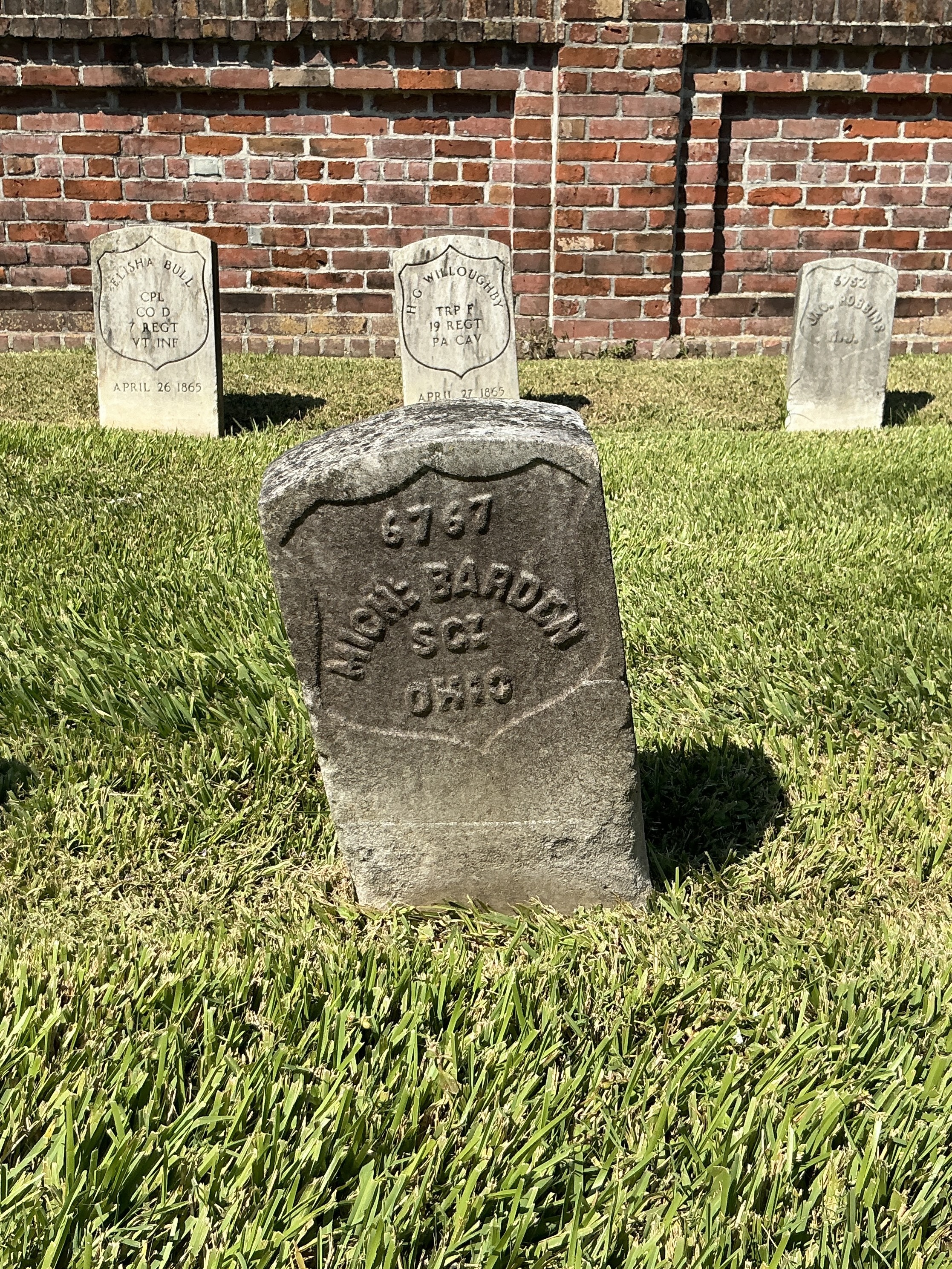 Front of historic upright marble headstone with recessed shield face.