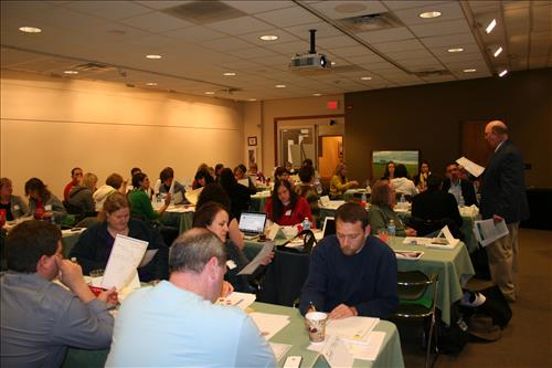 People sitting a tables with papers in front of them.