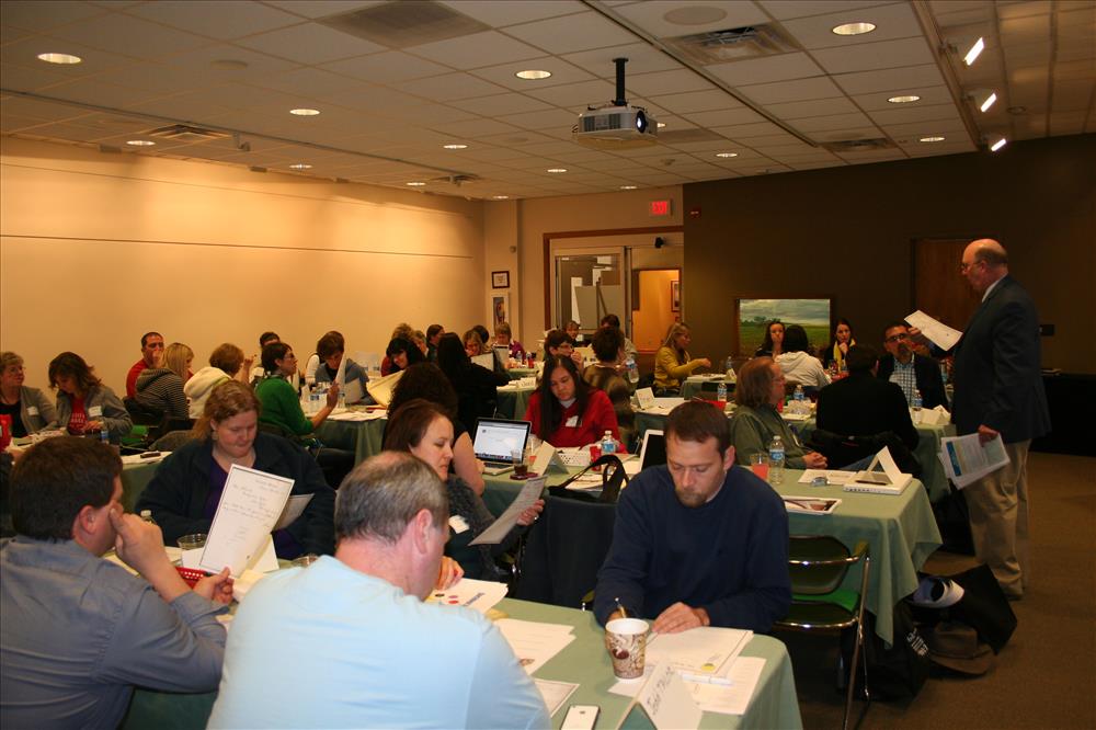 People sitting a tables with papers in front of them.