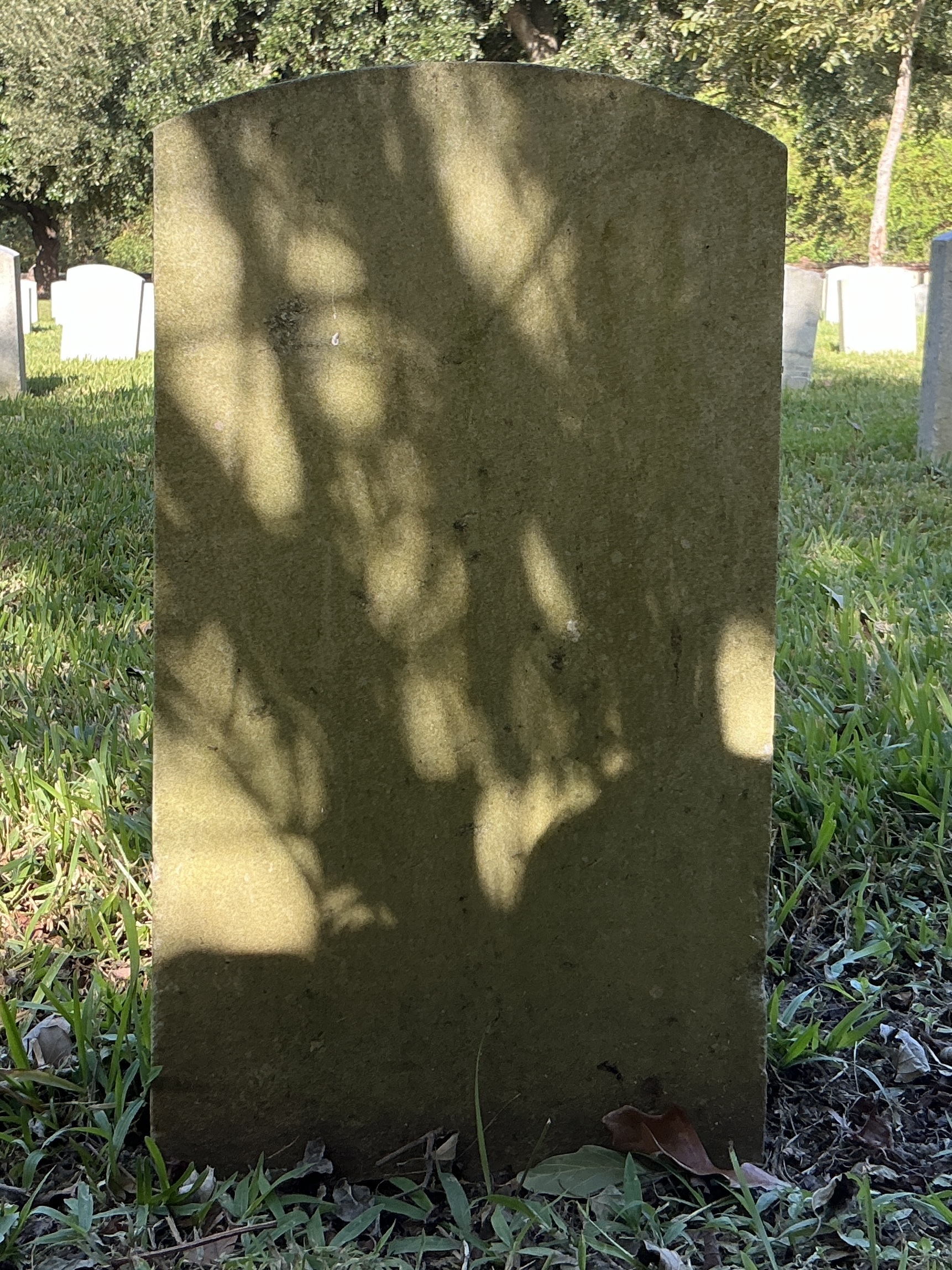 Back of historic upright marble headstone with recessed shield with recessed lettering face.