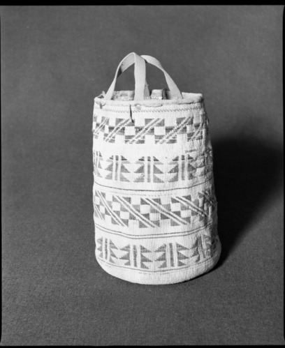 Marie Rozier Collection, Catalog No. 207. Object: Wasco twined bag. Dimensions: 11 x 6". Materials: Entirely of commercial cordage: jute, cotton, linen, wool, brain-tanned and smoked buckskin; webbing; rivets. Technology: Plain twined, down to righ slant of turns, spiral lattice binding for design elements. Collection History: Acquired from Eleanor Veale. It was in her parent's house in Maine. Probably ca. 1900, perhpaps before. Photographed by Michael Dixon, December 1982. Catalogued by Craig Bates and Barbara Beroza. Yosemite Collections, National Park Service.