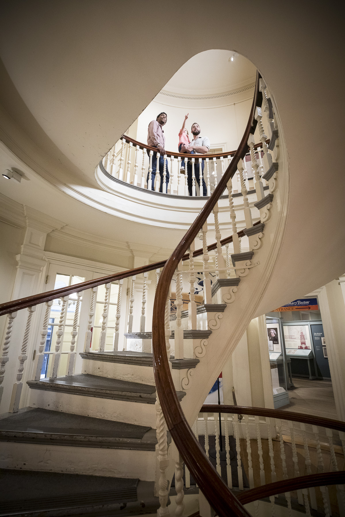 Large winding staircase with family on top floor