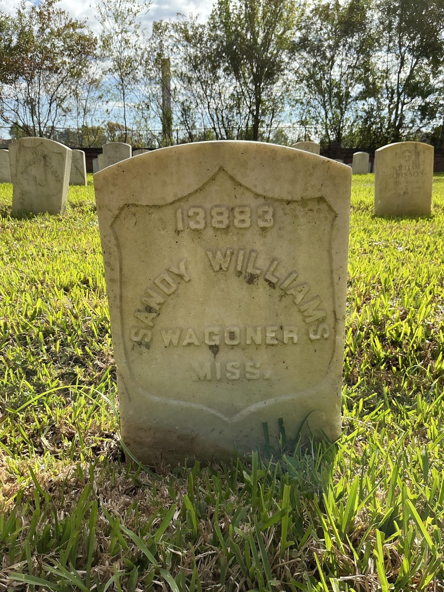 Front of historic upright marble headstone with recessed shield face.