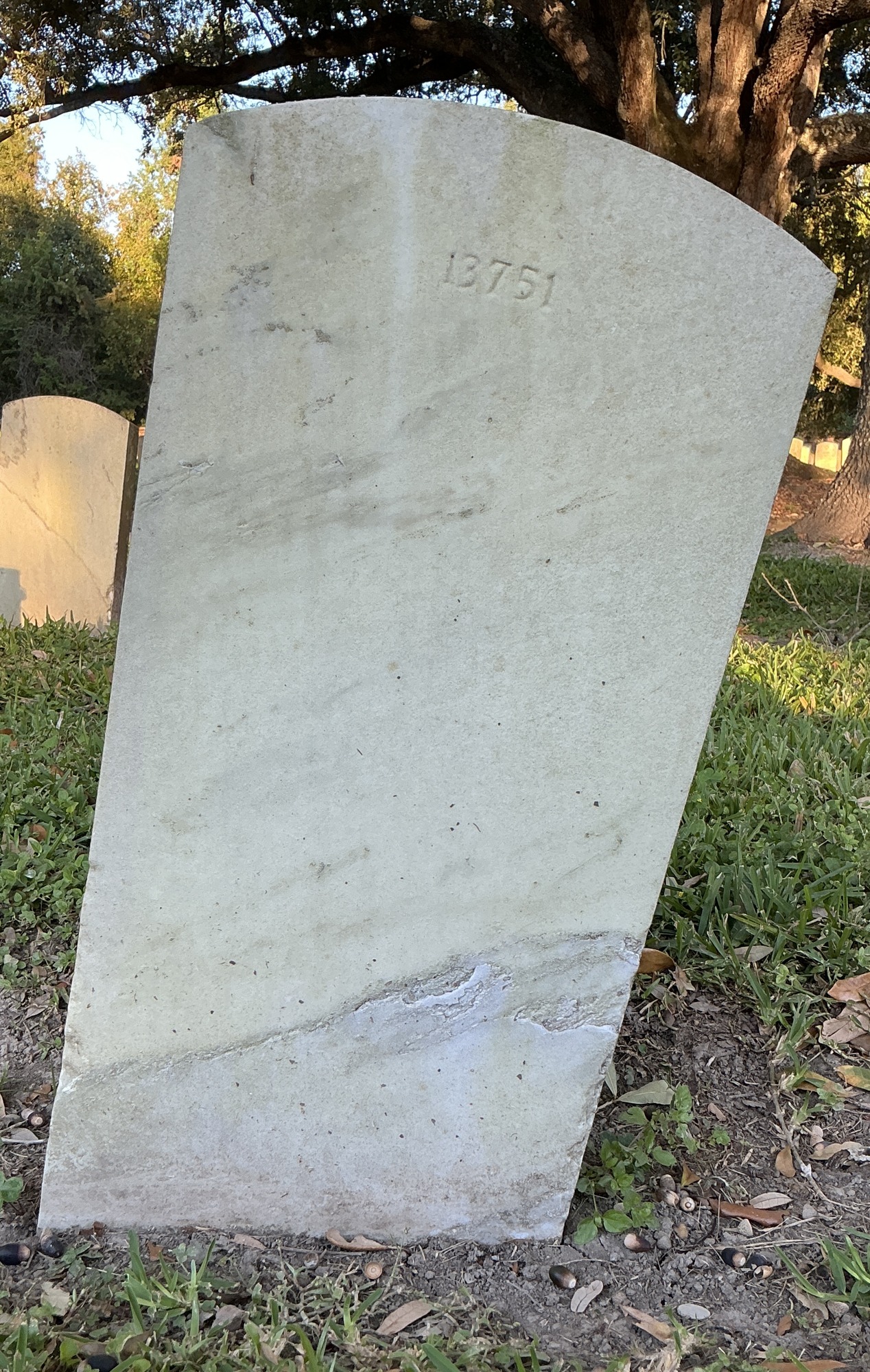 Back of upright marble headstone with flat face.