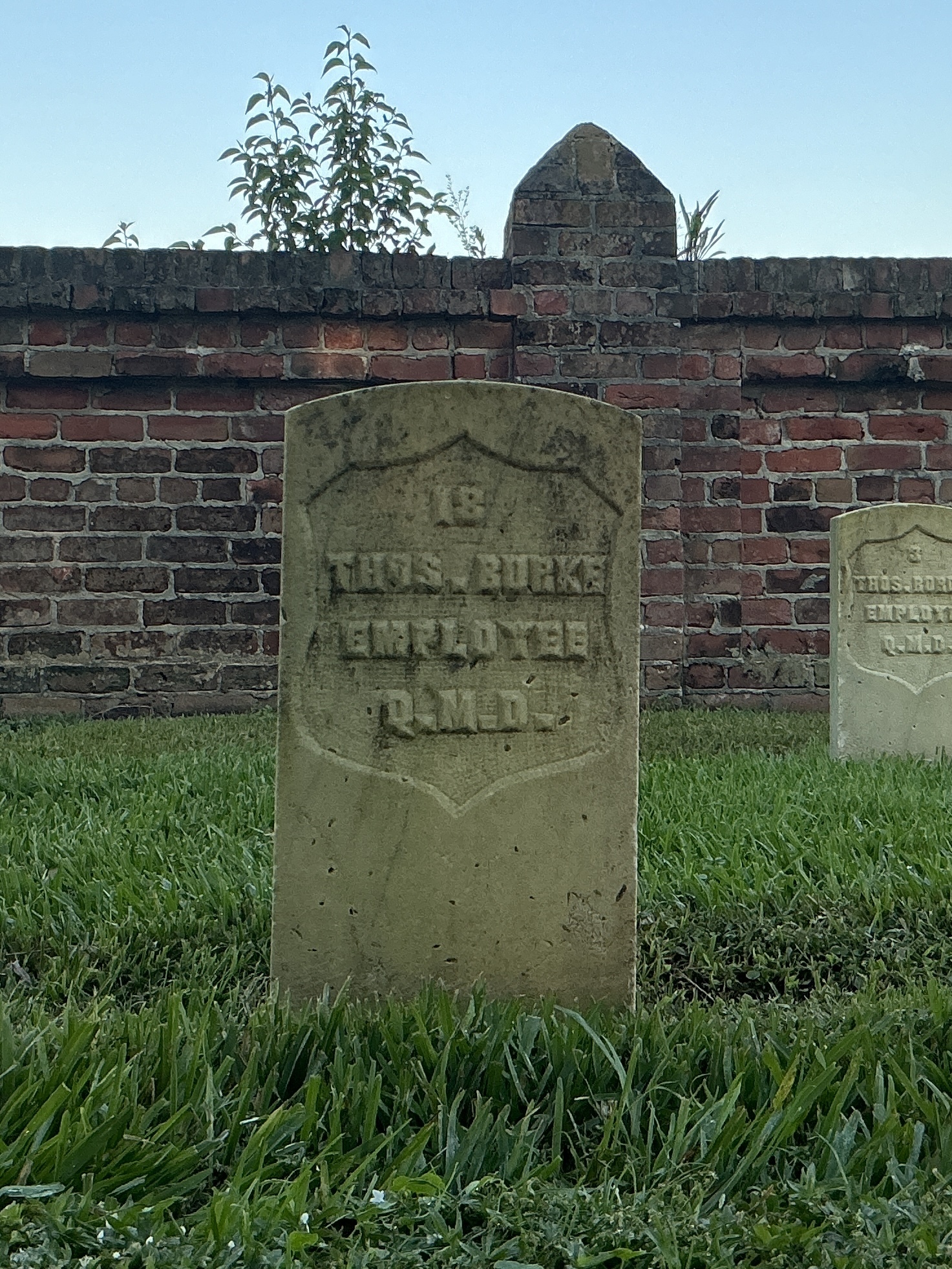 Front of historic upright marble headstone with recessed shield face.