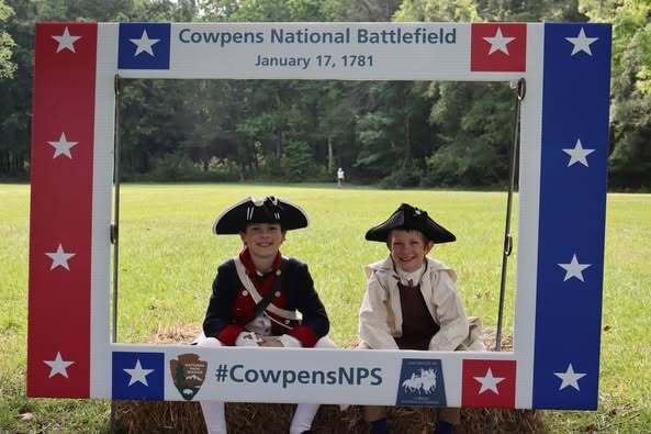 Two boys dressed as American continental and militia soldiers take a photo with the Cowpens selfie station that is overlooking the trail at Cowpens.