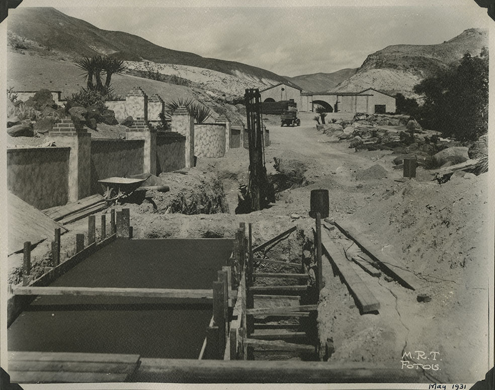This is an historic black and white photograph from the Scotty's Castle Historic Photograph Collection, Death Valley National Park of tunnel south of Scotty's Castle Hacienda leading to basement, also known as Multipurpose Facility (MPF) Tunnel. Under construction with some concrete poured, forms, and pile driver. May 1931. Photographed by Mat Roy Thompson.