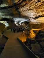A group gathers in a large cave room. 