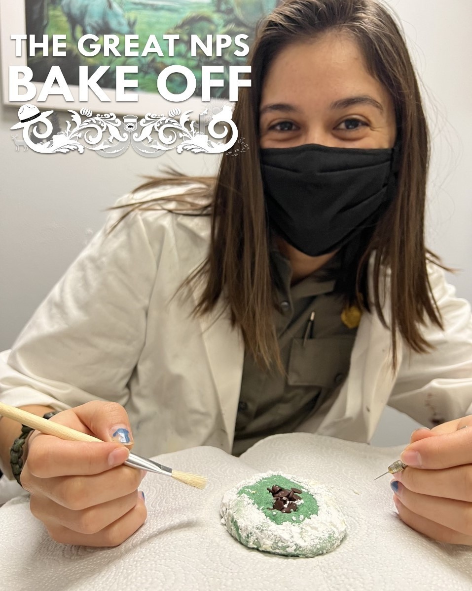 A ranger in a white coat working on a plaster jacket-inspired cookie. 