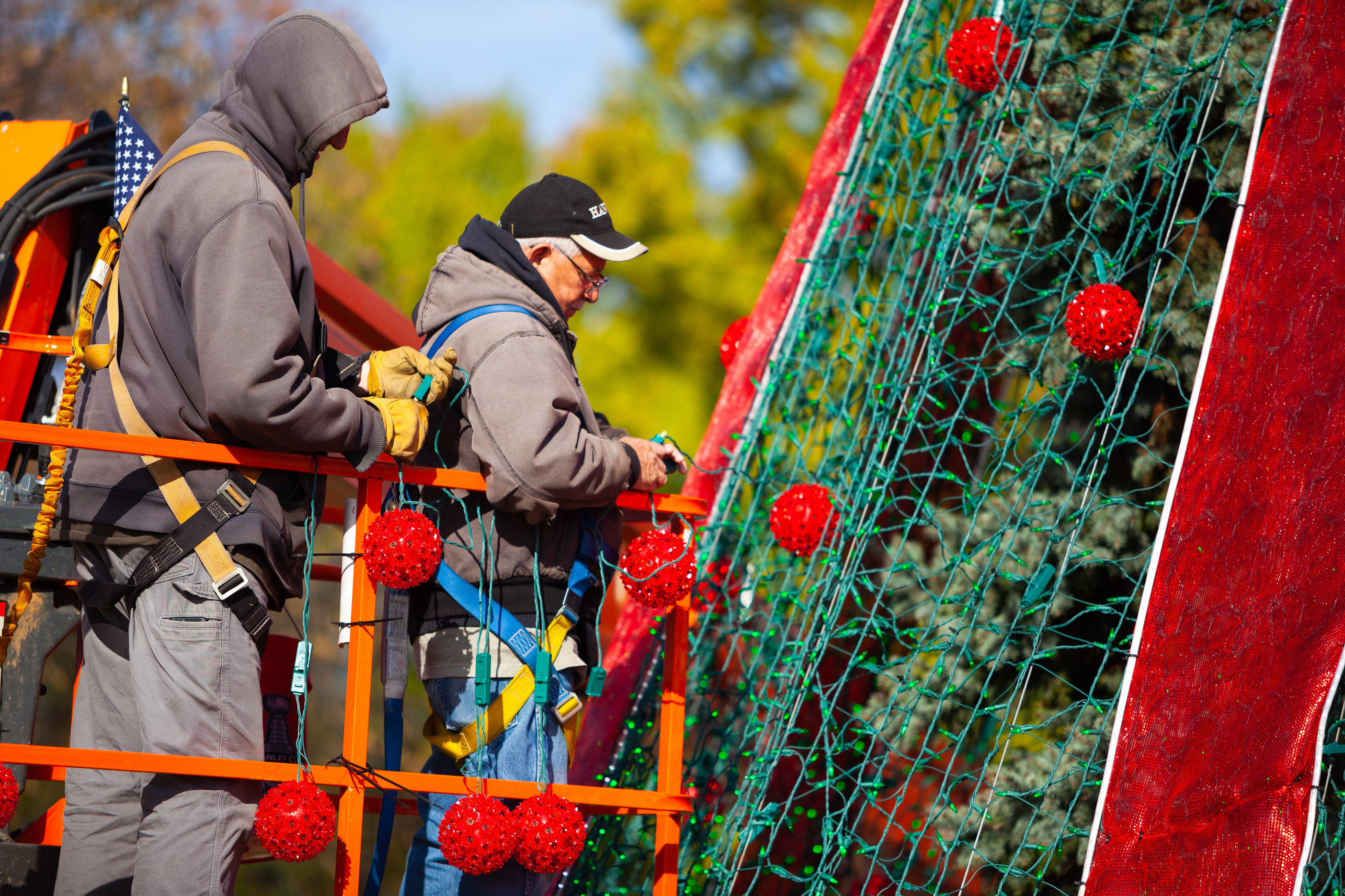 Two men add decorations to the 2018 National Christmas Tree.