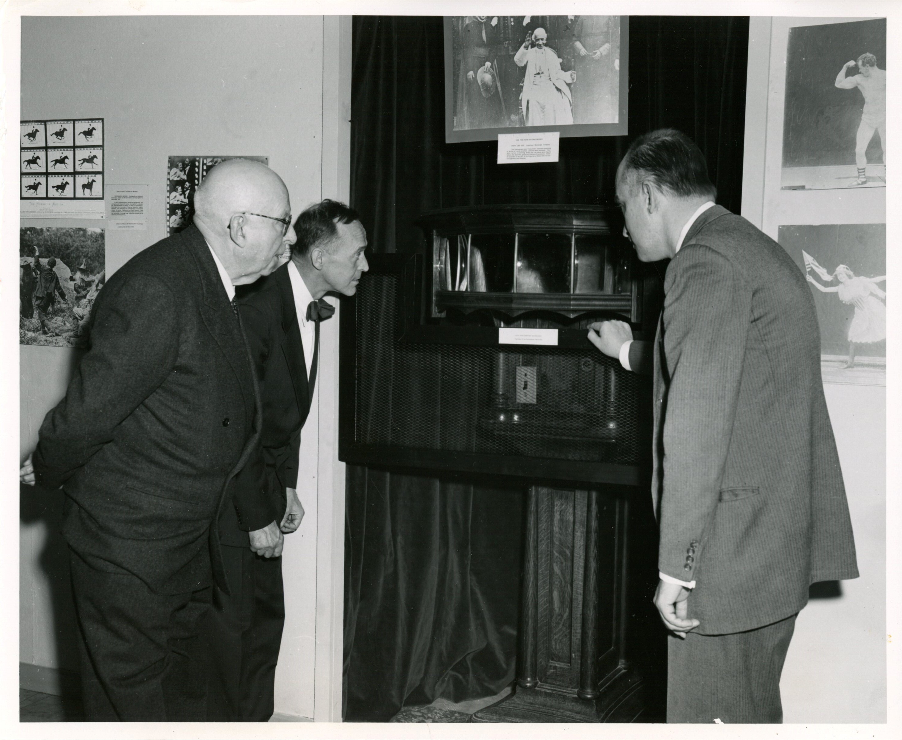 Vice Admiral Harold Bowen, of Edison Foundation, Verner W. Clapp, acting librarian of congress, and A.J. Wedderbrun, Smithsonian institution, looking at mutoscope on exhibit.