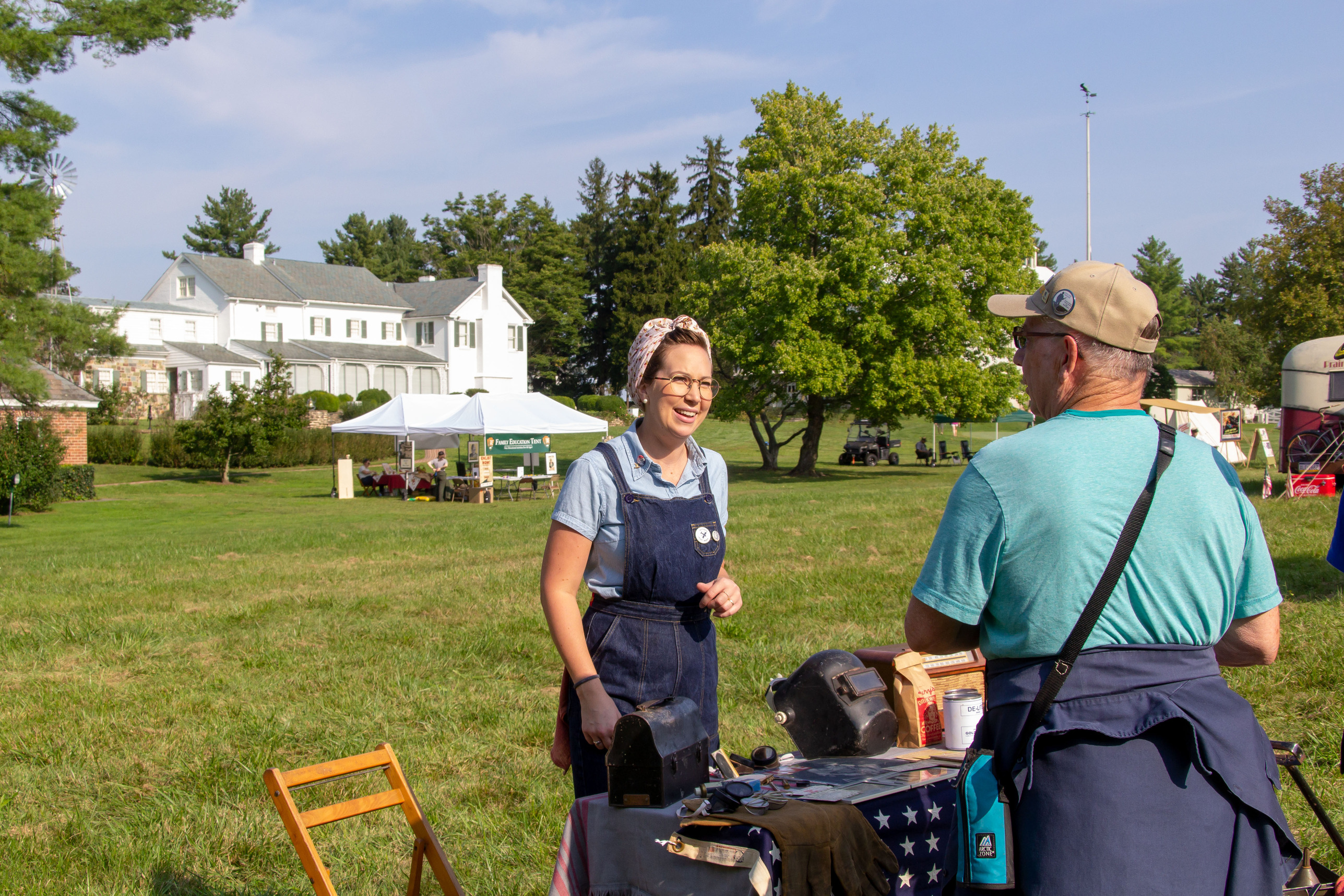 A woman presenting her home front booth to a visitor.