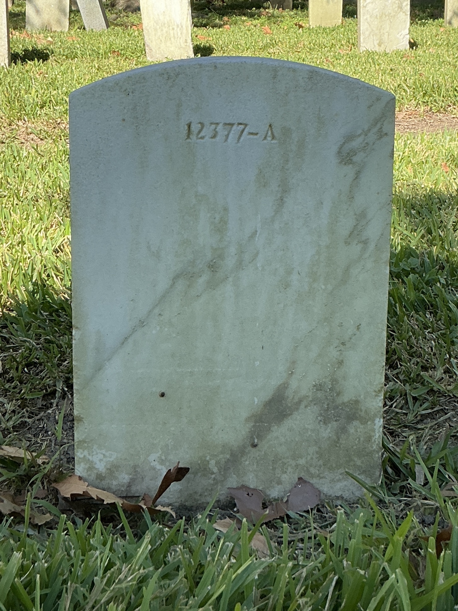 Back of upright marble headstone with flat face.