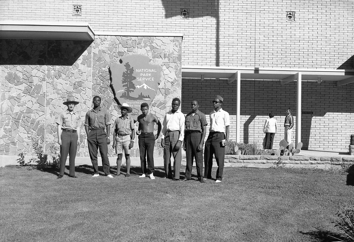 Supervisory Park Ranger Clyde Maxey from Yellowstone National Park and African American students standing in front of Mission 66 Visitor Center and Museum. Group was on tour of Zion National Park.
