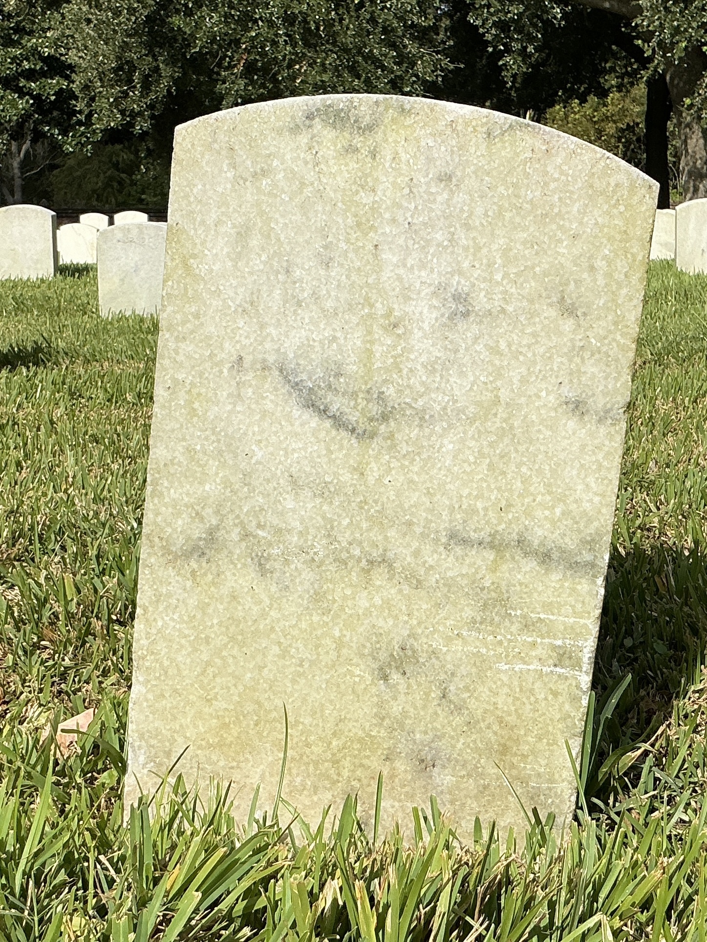 Back of historic upright marble headstone with recessed shield face.