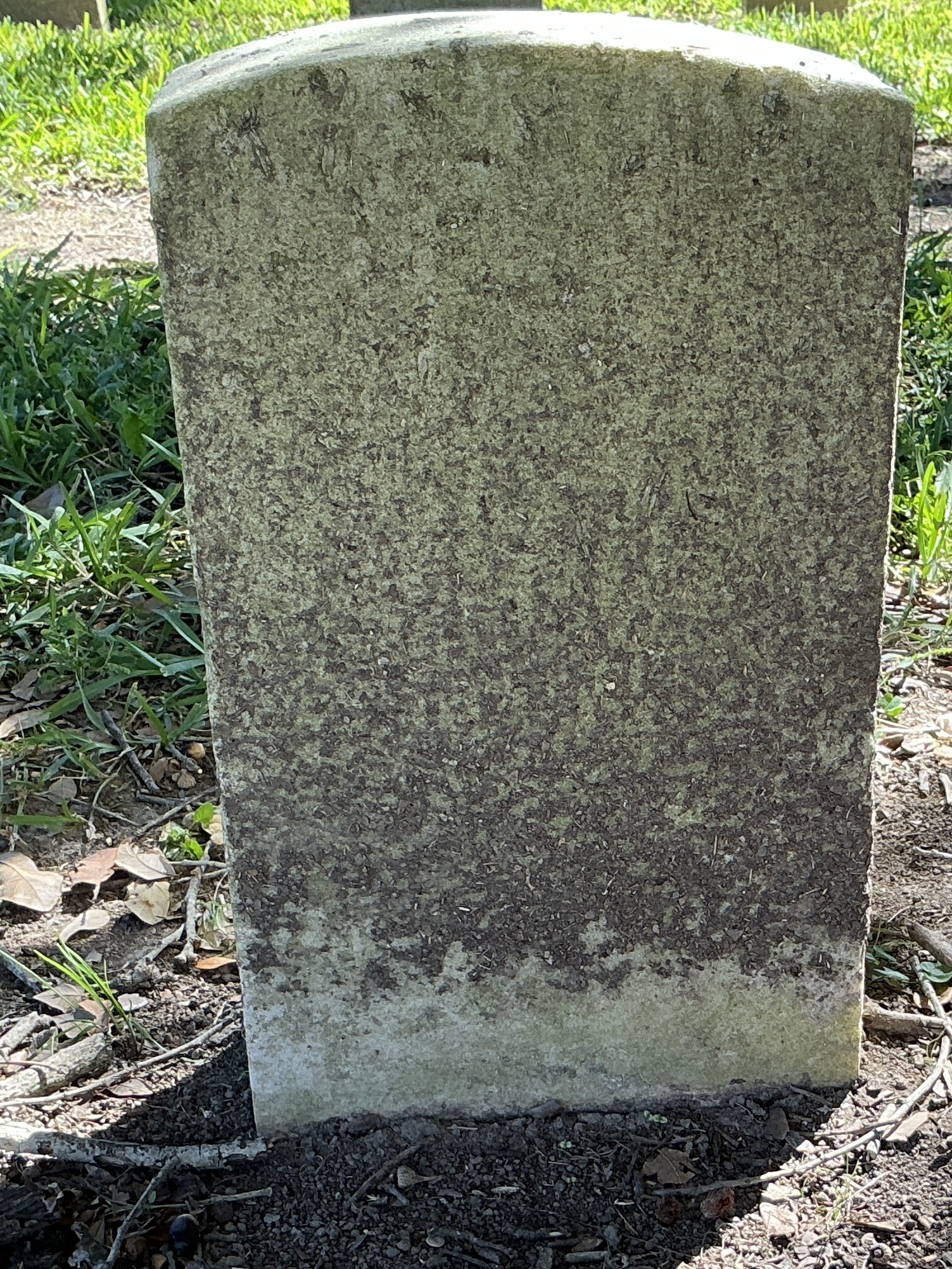 Back of historic upright marble headstone with recessed shield face.