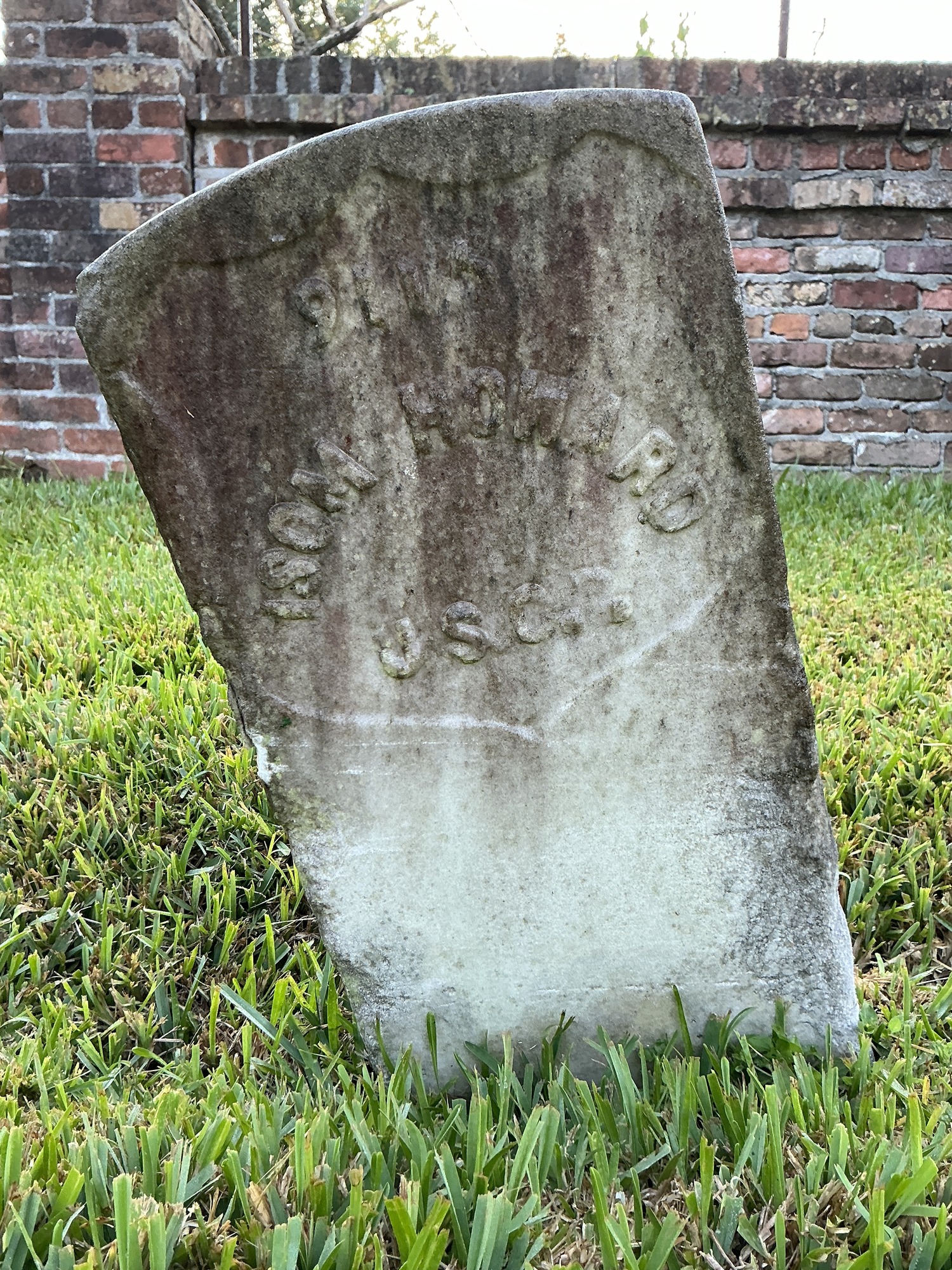 Front of historic upright marble headstone with recessed shield face.