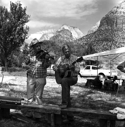 Two musicians performing guitar and fiddle at the third annual Folklife Festival at Zion National Park Nature Center, September 7-8, 1979.