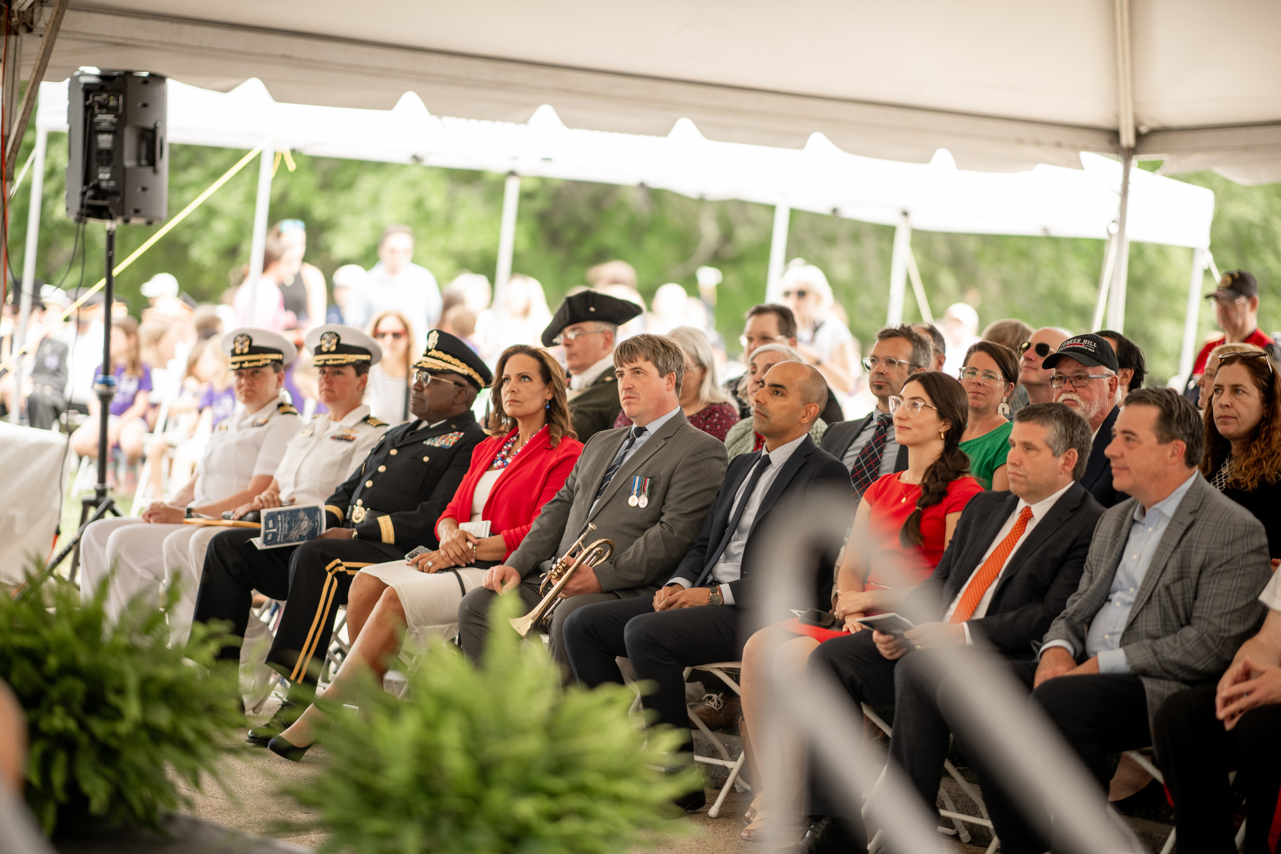 Rows of individuals seated in the audience. They look ahead of them attentively. 
