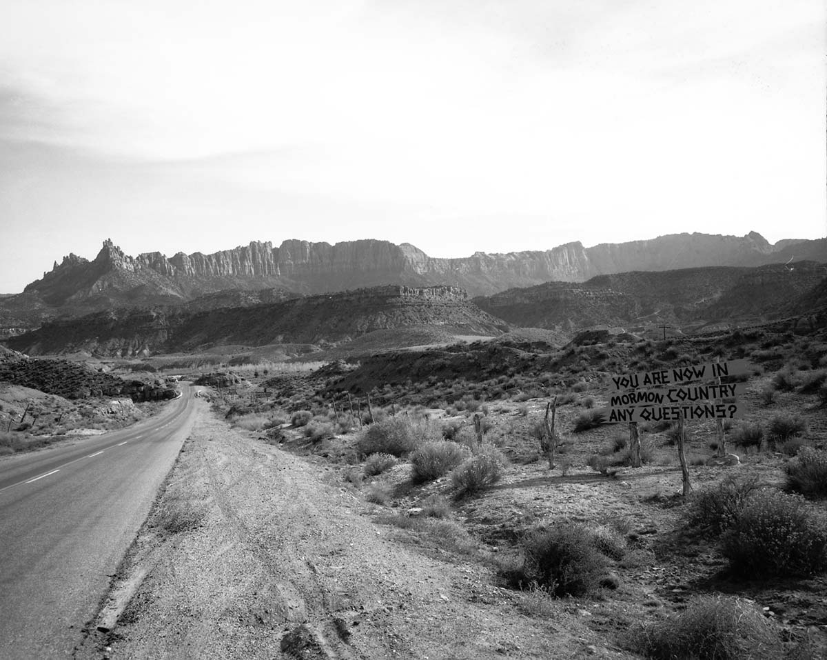 A Grandma's Kitchen and Motel sign on Utah State Route 15 (now State Route 9). The Grandma's signs were black on yellow and at least one was visible at almost every turn from Virgin, Utah to Zion. These photographs were used as documentation for the proposed cleanup of undesirable signs and debris along the route to Zion. This sign reads: 'You are now in Mormon country any questions?'