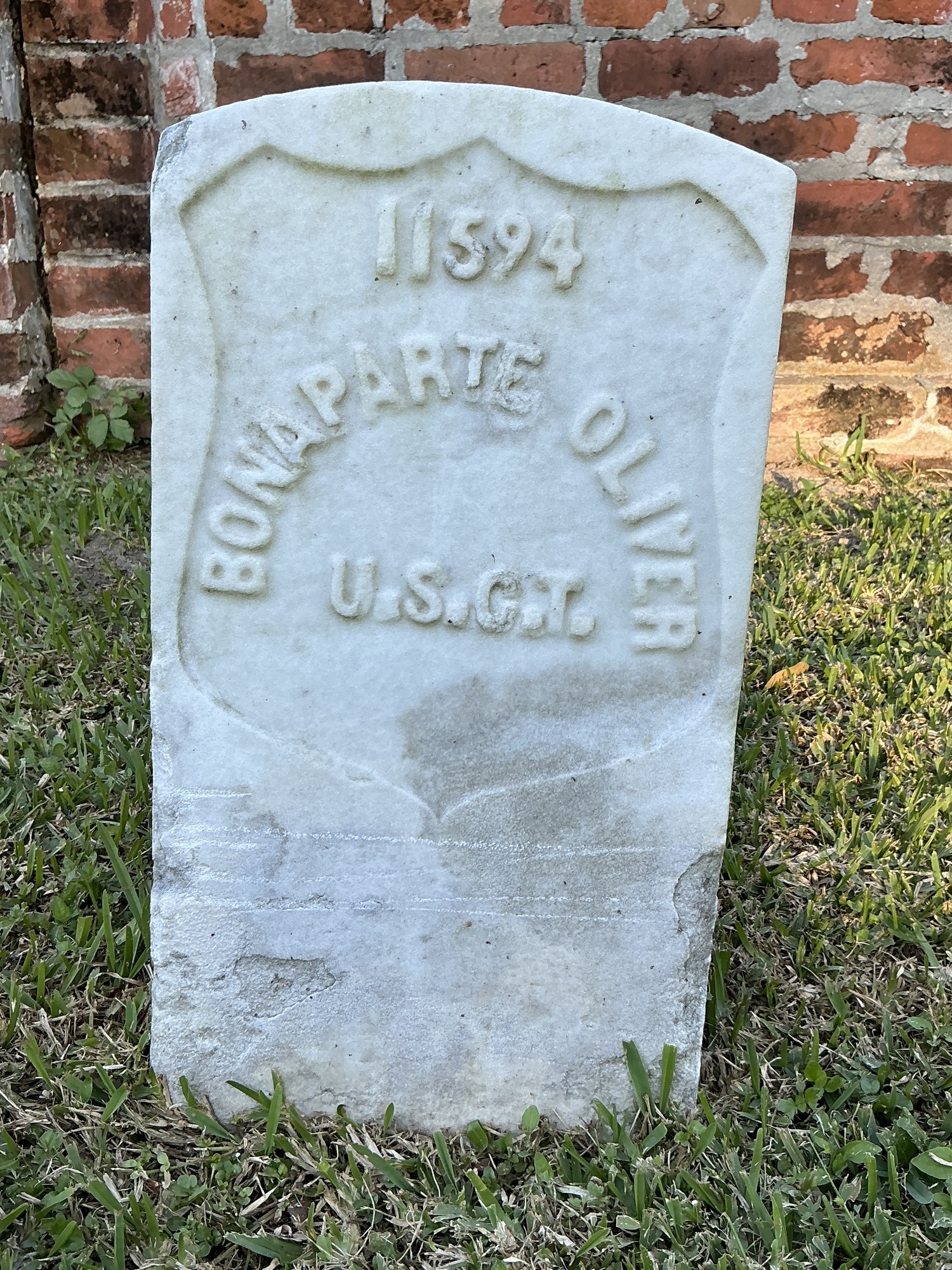 Front of historic upright marble headstone with recessed shield face.