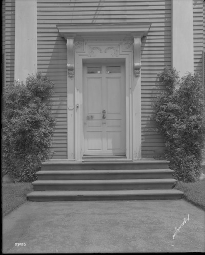 Black and white photo of large ornate door.
