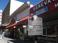 Some stores close to a large building.