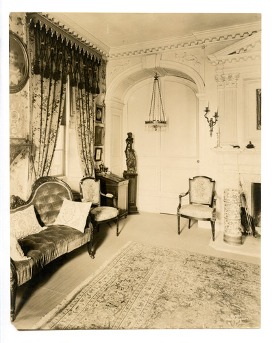 Black and white photograph of 19th century parlor featuring Georgian moldings on back wall.