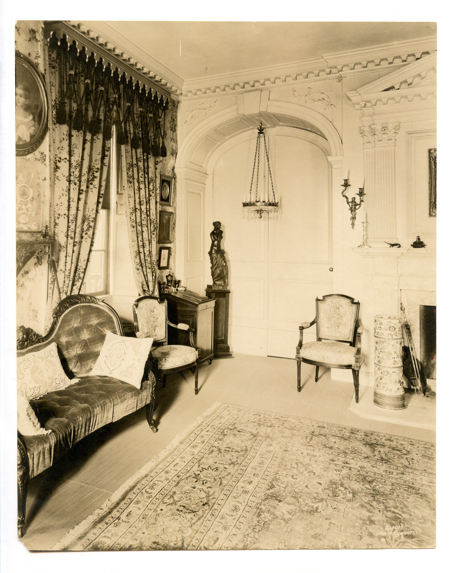 Black and white photograph of 19th century parlor featuring Georgian moldings on back wall.