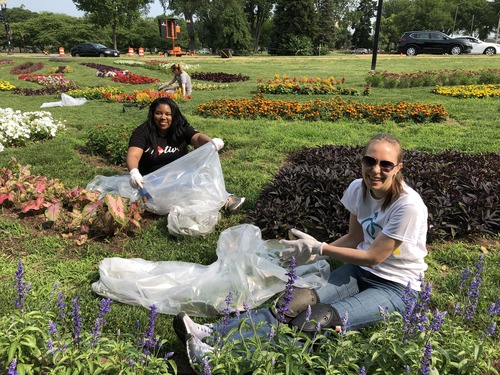 Two women weed flower beds
